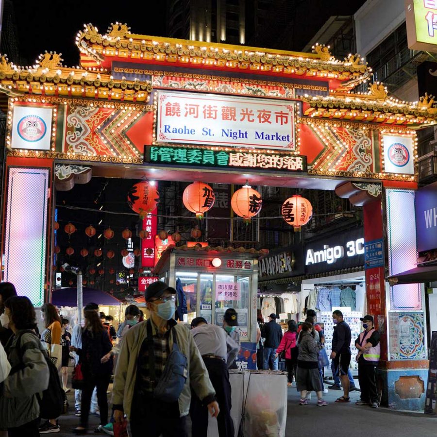 People walk in front of the entrance of Taipei's Raohe Street Market.